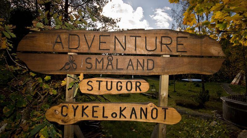 Skylt med texten: Adventure Småland stugor, cykel och kanot